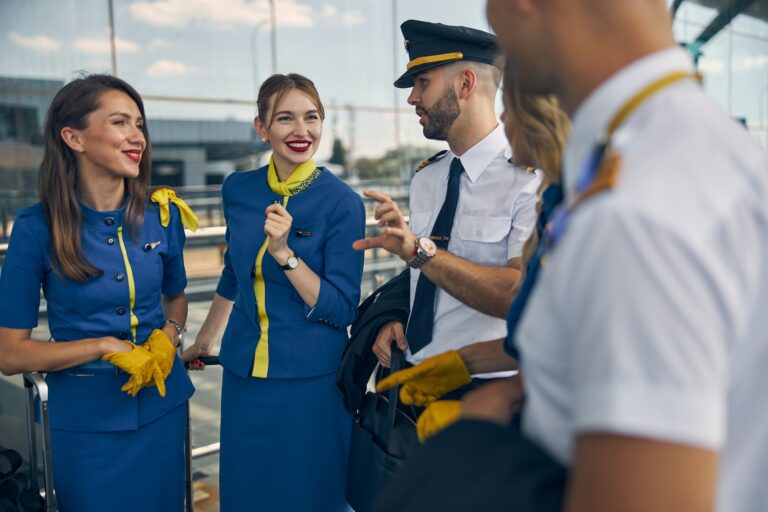 Cheerful stewardesses talking with pilots on the street
